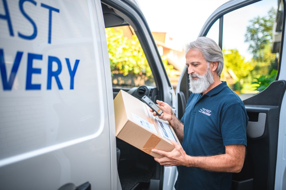 A delivery driver scans a package in Houston, TX